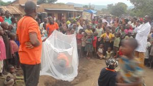 A Man with a Net Surrounded by a Group of People.