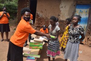 Distributing scholastic materials to student Mary with her guardian.